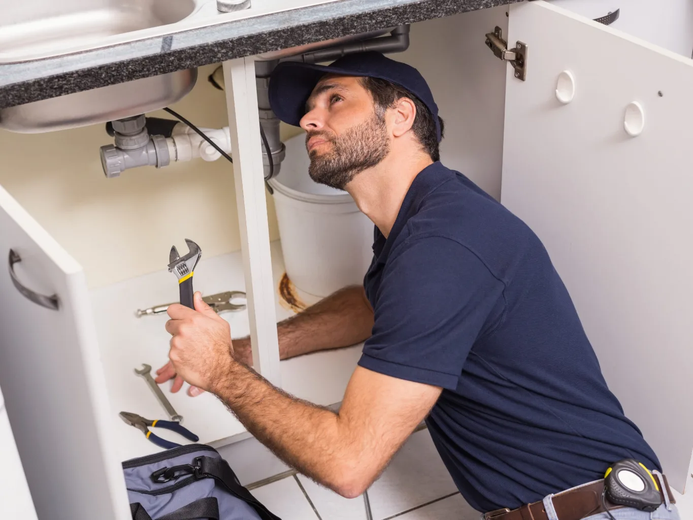 Plumber completing a final quality inspection beside a residential water heater